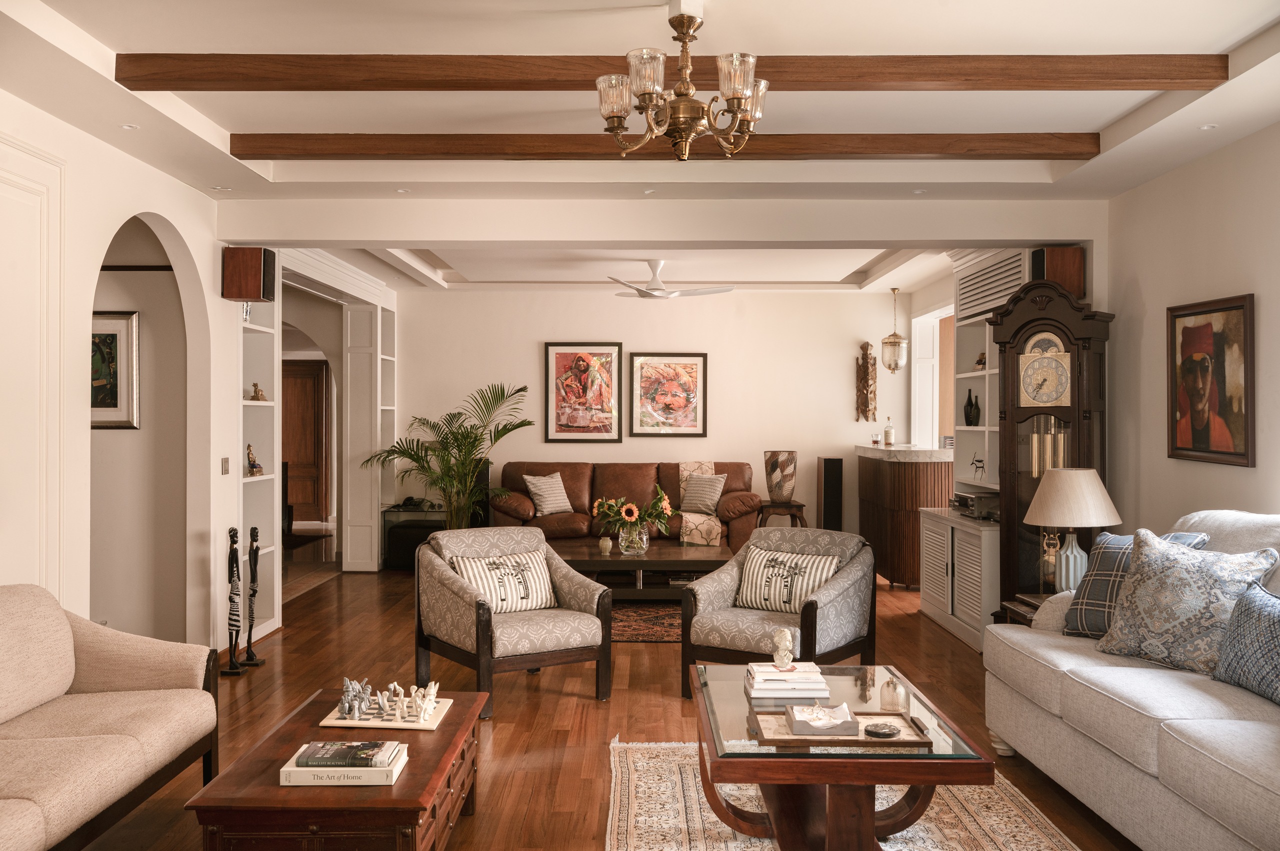 Refined living room with timber-beamed ceiling and chandelier at Prestige Eldorado, by the Construction Associates interiors team